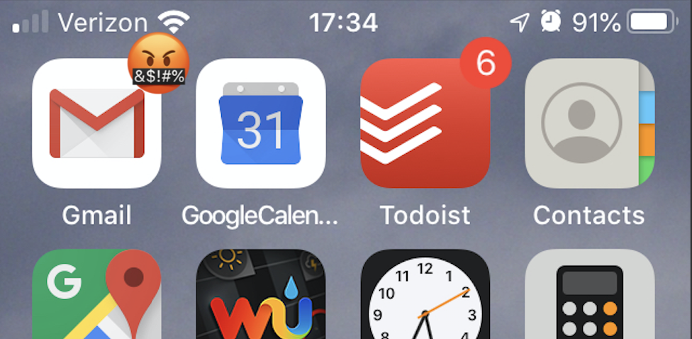 An iPhone home screen with an angry face on the e-mail app icon