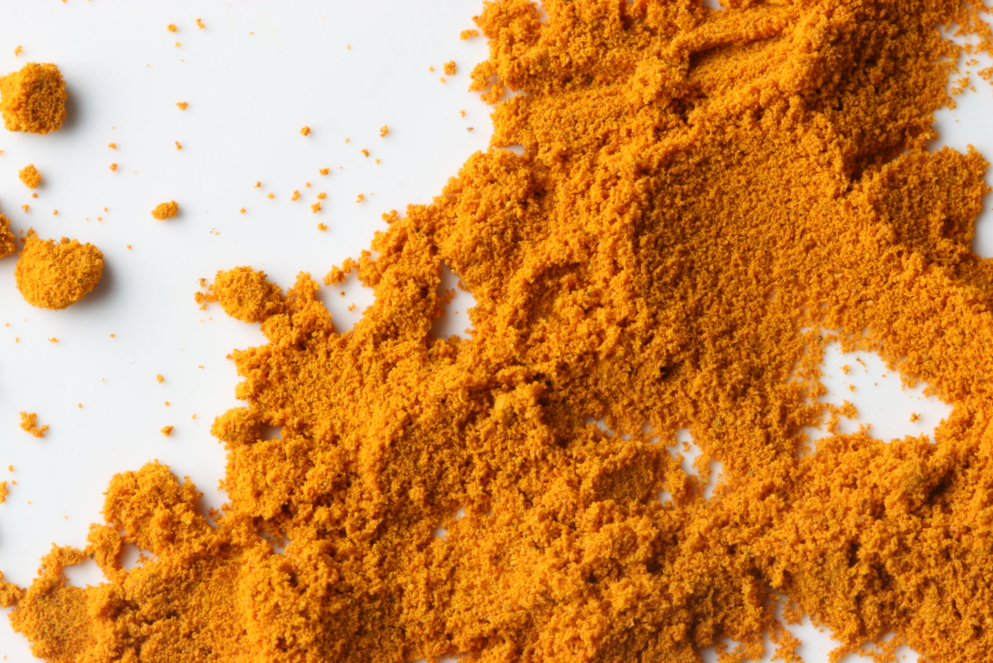Bright orange-yellow powder scattered on a white surface